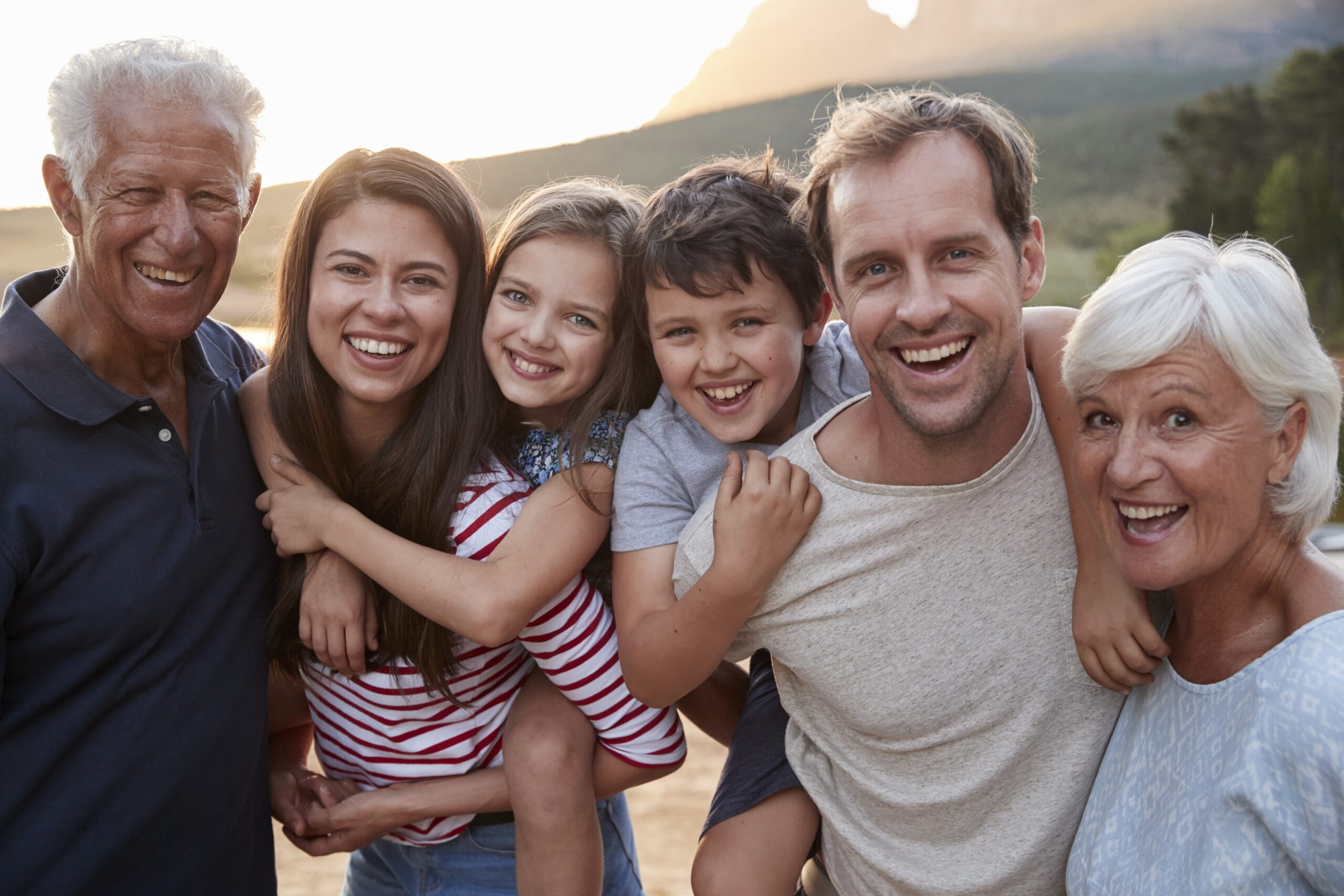 Portrait Of Multi Generation Family On Countryside Walk By Lake Family Dentistry